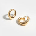 Minimalist gold hoop earrings with a smooth polished finish on a white background