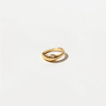 Minimalist gold ring with a smooth curved design and subtle stone detail on a white background